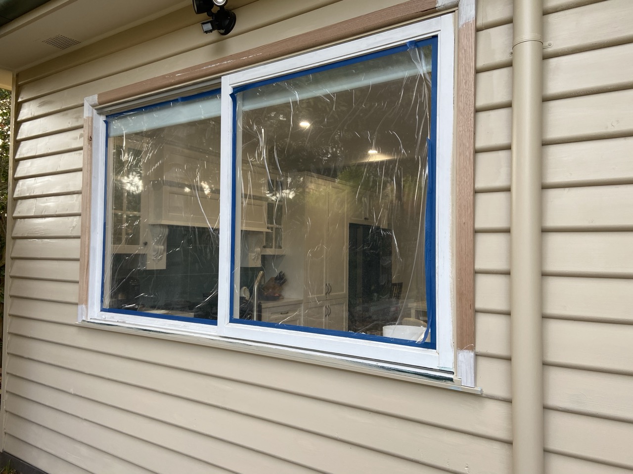 Replacement window being finished on a weatherboard home