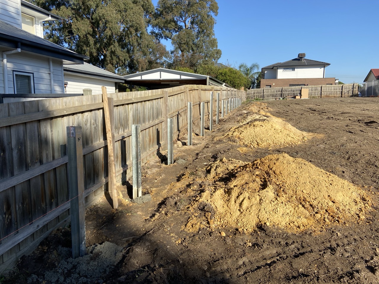 Retaining wall steel posts installed along a boundary